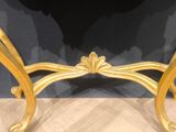 a gold table with a marble top on a wooden floor