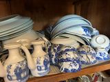 many blue and white plates and vases on a shelf