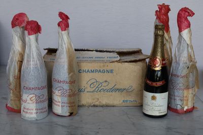 five bottles of champagne sitting next to a box of wine