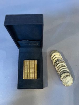 a small box of coins and a small coin on a table