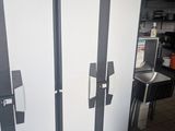 two refrigerators that are standing in a kitchen