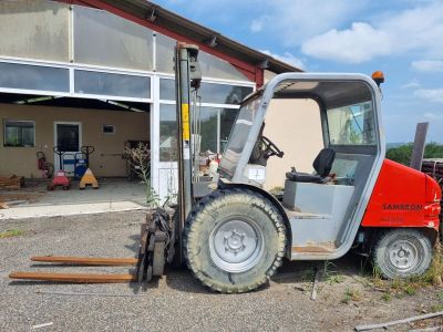 un chariot élévateur à fourche garé devant un bâtiment
