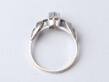 a close up of a silver ring with a diamond on top of it