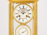 une horloge dorée surmontée d'une station météo