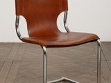 an image of a brown leather and chrome chair on a wooden floor