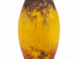 a brown and yellow vase sitting on a white surface