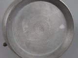 silver plate with a circular design on it on a white surface