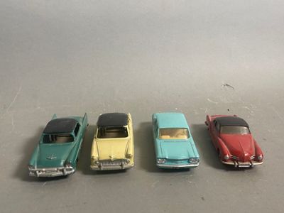 four toy cars are lined up in a row on a table