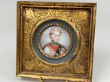 an antique miniature portrait of a young boy in a gold frame