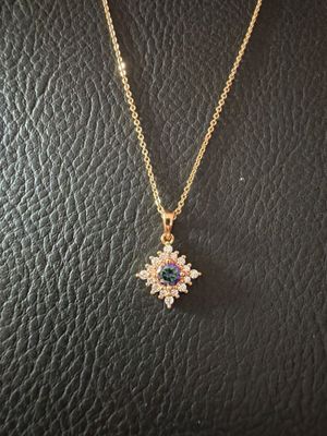 un collier en or orné d'un pendentif en forme de fleur, monté sur un support en cuir noir
