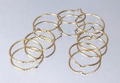 a lot of gold rings sitting on a white surface