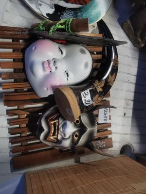 de nombreux masques posés sur une étagère dans une pièce