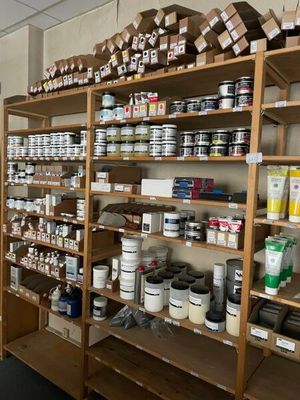 many shelves of paint and other paints in this room