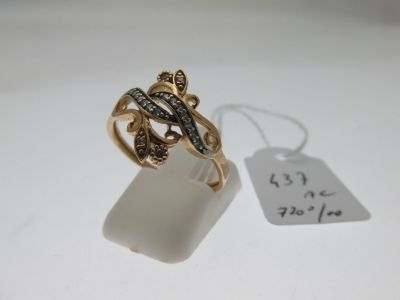 un gros plan d'une bague en or sertie de diamants noirs et blancs