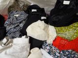 de nombreux vêtements de toutes sortes étalés sur un lit