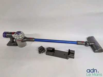 un gros plan d'un aspirateur sans fil muni d'une poignée bleue