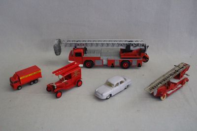 un camion de pompiers miniature, une voiture et d'autres véhicules miniatures posés sur une table