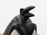 a close up of a black and white penguin figurine on a table