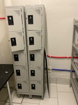 four metal lockers in a room with a black table