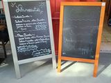 deux tableaux noirs posés l'un à côté de l'autre sur le trottoir