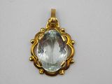 an image of a gold pendant with an aquamarine stone