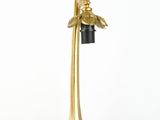 brass table lamp with a black shade and a gold bird on it