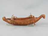 an image of a wooden boat on a stand on a white surface