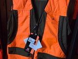 an orange vest with a tag on it sitting on a shelf