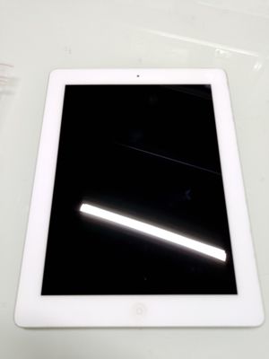 une tablette posée sur une table, sur fond noir