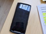 un téléphone portable posé sur un bureau, à côté d'une feuille de papier