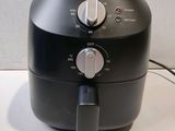 a black air fryer sitting on a counter top