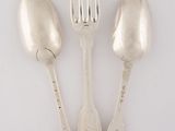three silver spoons and a fork on a white surface