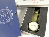 a box with a watch inside of it on a white surface