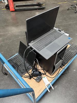 deux ordinateurs portables et un clavier posés sur un chariot dans un entrepôt