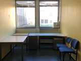 une pièce dans laquelle se trouvent deux bureaux et deux chaises