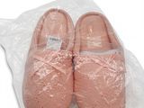 une paire de chaussons roses posée sur un sac en plastique