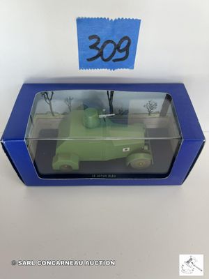 La boîte est ouverte et laisse apparaître un petit camion vert dans son emballage.