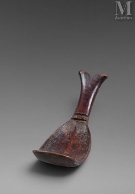 un vase marron muni d'une poignée en bois, posé sur une table