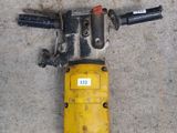 an image of a drill is laying on the ground next to a piece of metal