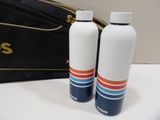 two water bottles sitting next to a bag on a table
