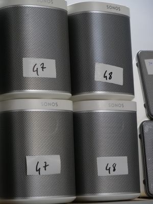 a stack of speakers sitting on a shelf next to a cell phone