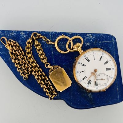 a gold pocket watch with a chain around it