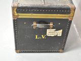 a black suitcase sitting on a white surface with a label on it