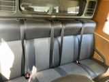 a seat in the back of a bus with a mirror on it