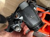 a person holding a camera with a strap on it