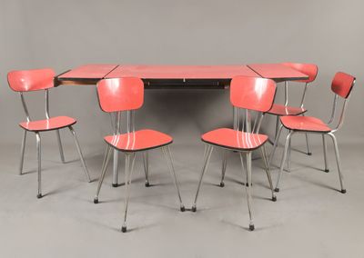 Six chaises rouges sont disposées autour d'une table au plateau noir.