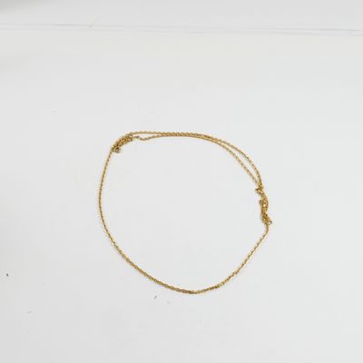un bracelet en chaîne dorée orné d'un nœud sur un fond blanc