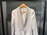 une veste blanche suspendue à un cintre dans un placard