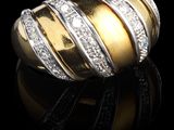 gros plan d'une bague en or et diamants sur une surface noire