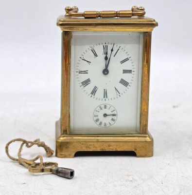 une petite horloge en or entourée d'une chaîne